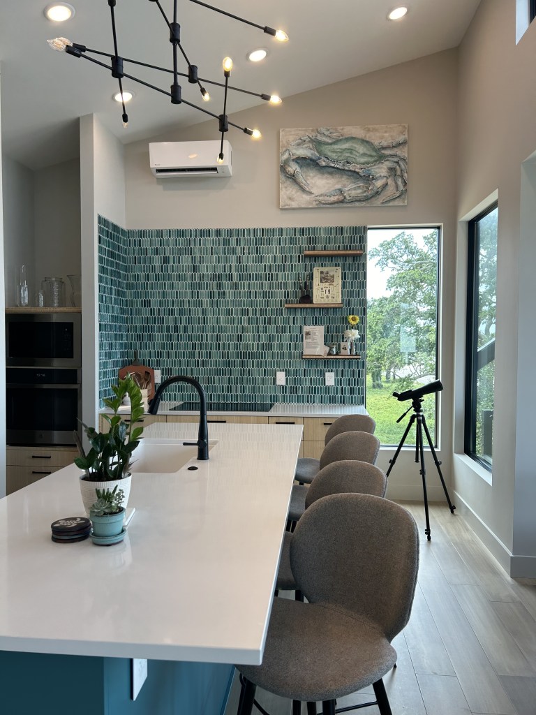 Elizabeth Hall Designs designed a kitchen that incorporates elements and colors from the beach in this beautiful coastal home.