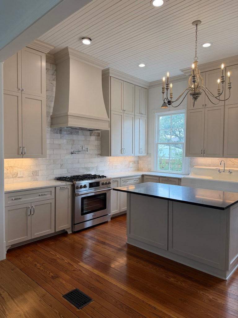 Farmhouse kitchen renovation with beige cabinets, wood floors and 12' ceilings.