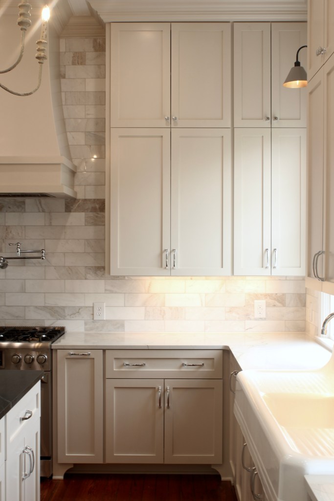Farmhouse kitchen renovation with beige cabinets, wood floors and 12' ceilings.