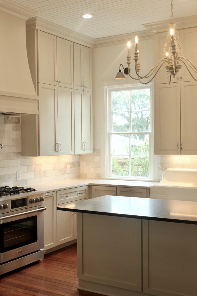 Farmhouse kitchen renovation with beige cabinets, wood floors and 12' ceilings.